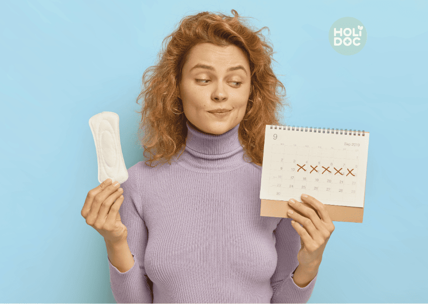 une jeune femme regarde son calendrier pour faire le décompte des jours avant ses règles, afin de comprendre où elle en est dans son cycle menstruel.