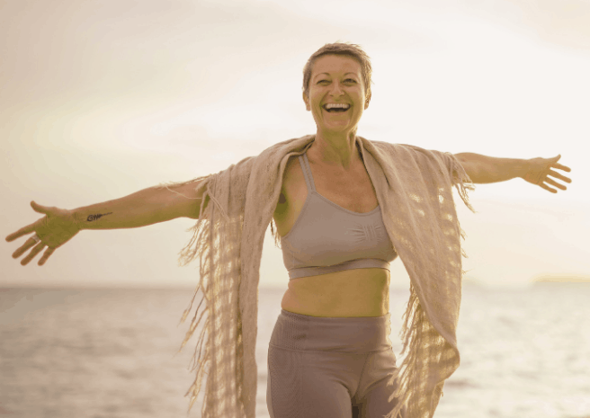 femme senior heureuse et en pleine santé s'amusant à la plage.