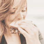 femme heureuse mangeant un sandwich